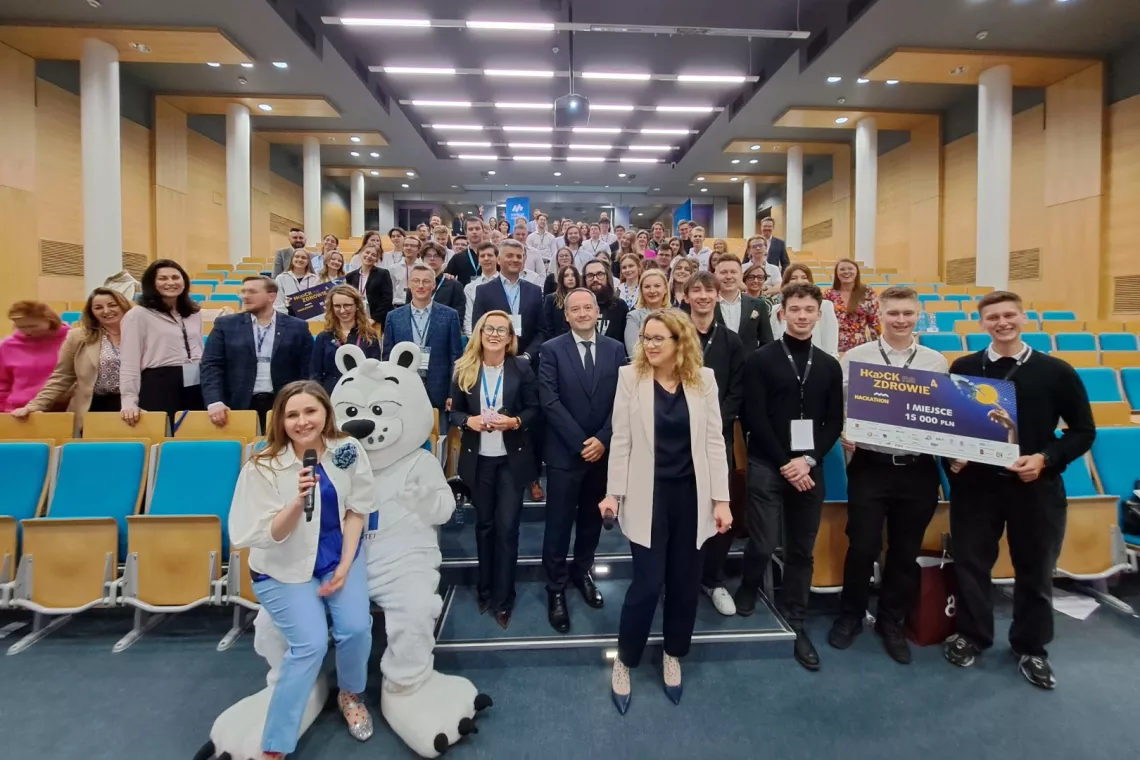 Liczna grupa osób stoi w audytorium