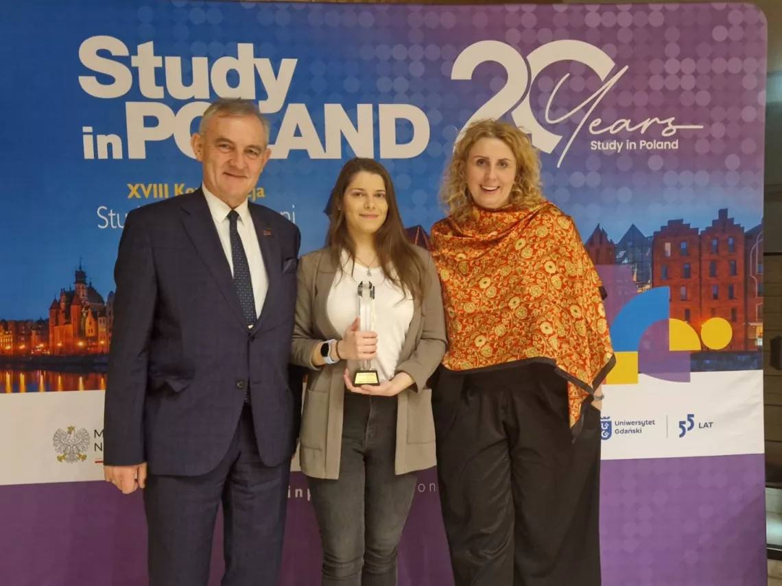 Laureatka konkursuz nagrodą w towarzystwie dwóch osób