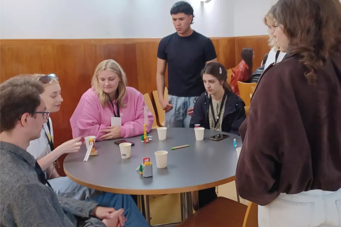 Grupa studentów siedząca przy okrągłym stole