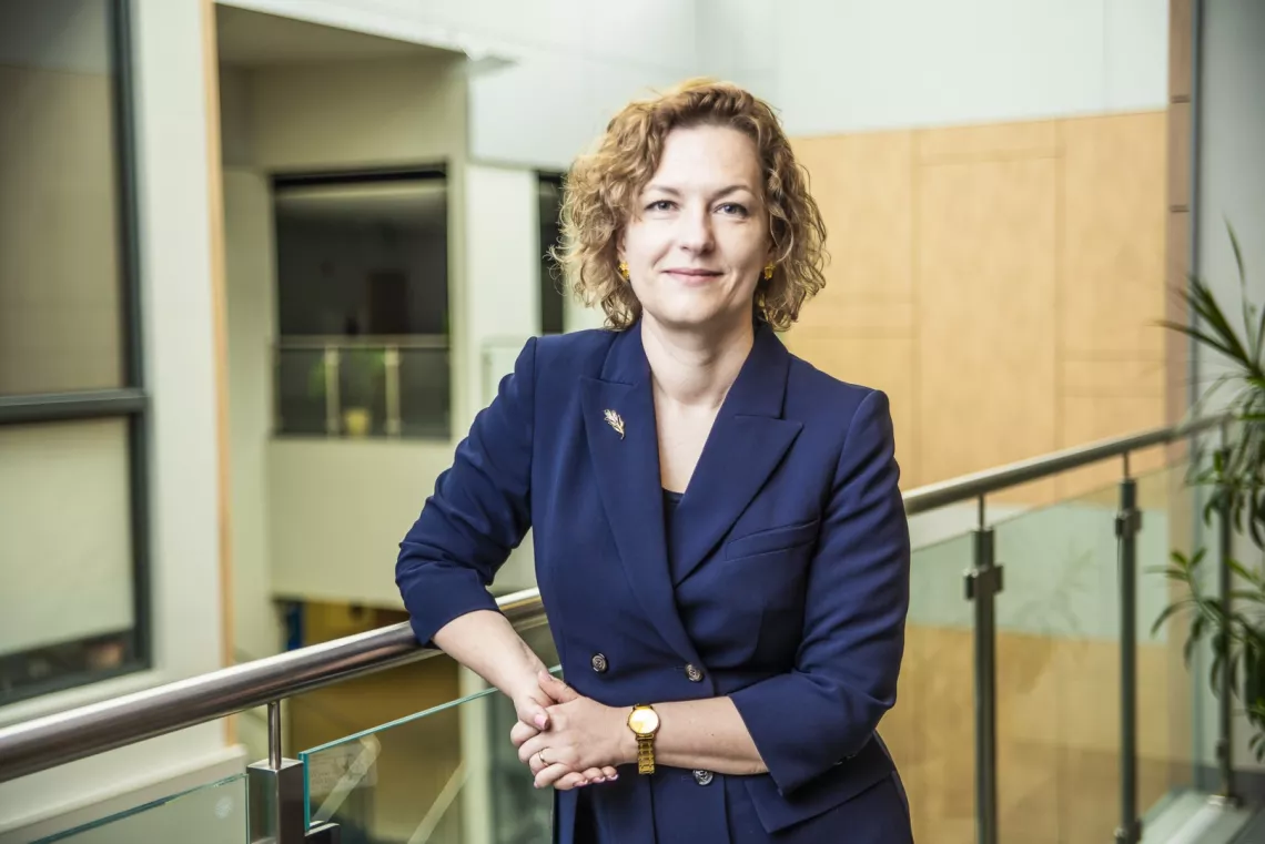 Kobieta w marynarce z przypiętą broszką 