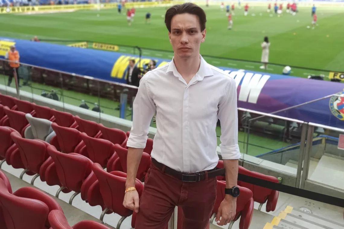 Młody mężczyzna stoi na trybunie stadionu sportowego