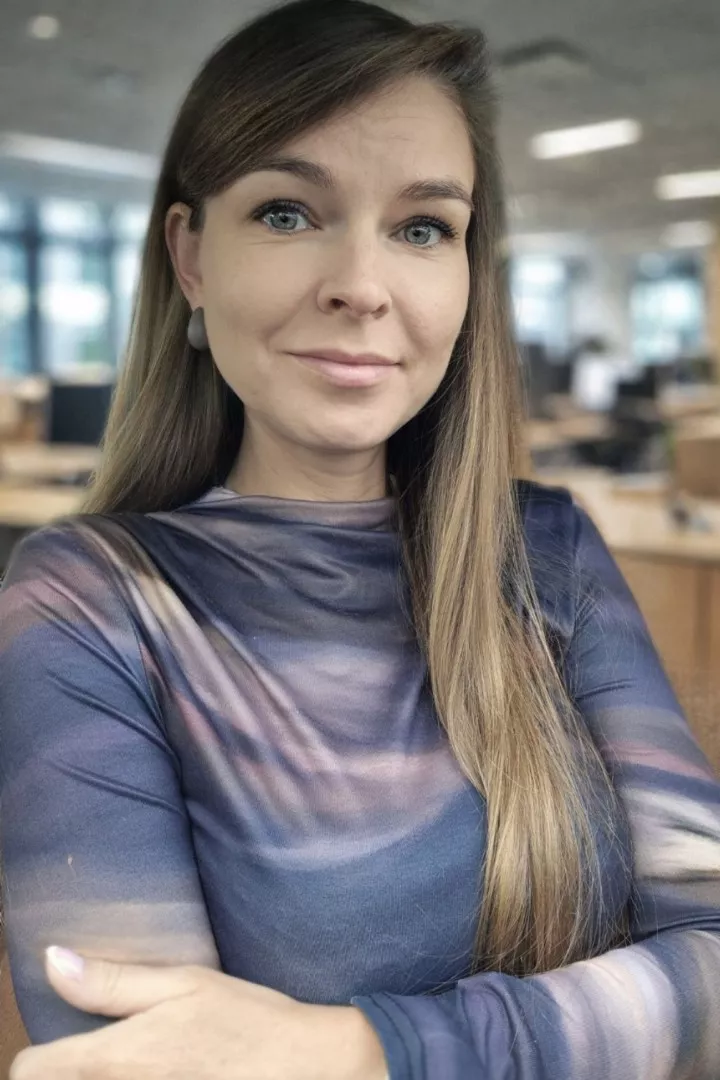 Młoda kobieta z długimi, rozpuszczonymi włosami, z założonymi rękoma