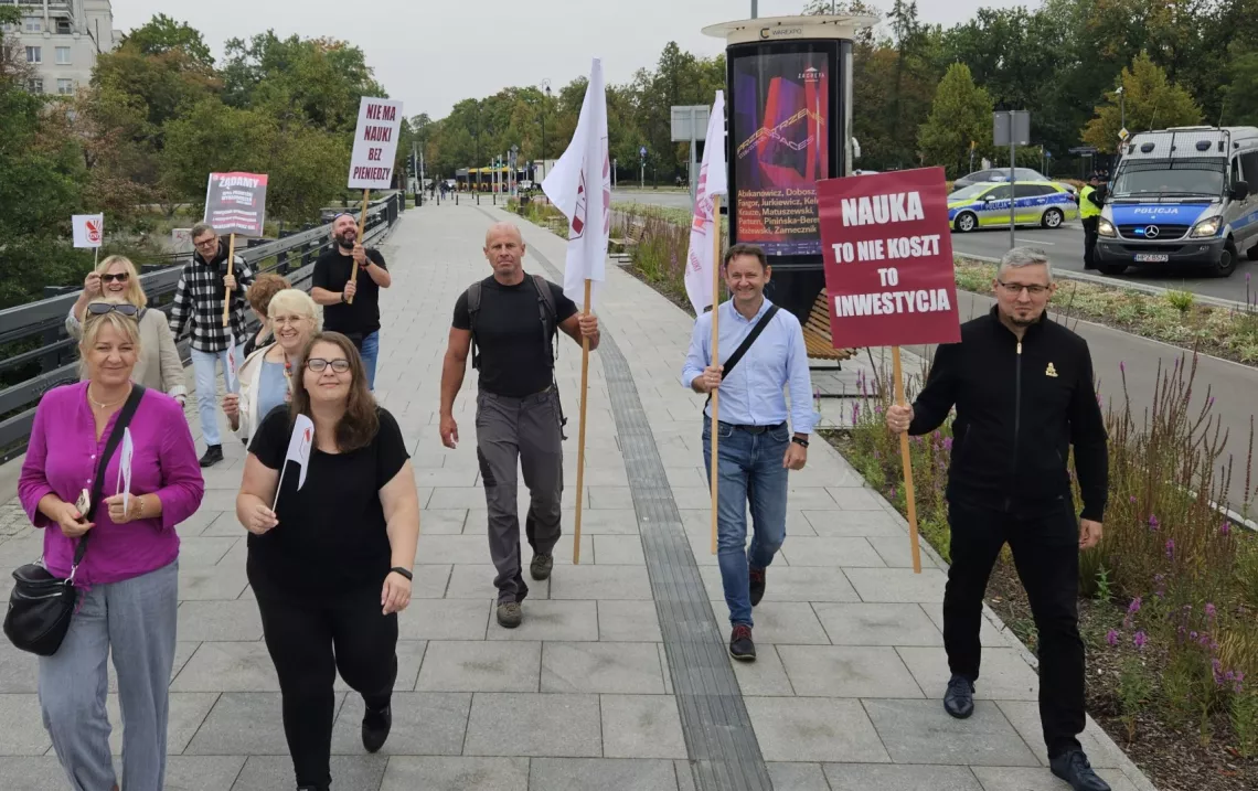 Grupa osób z flagami ZNP w drodze na monifestację