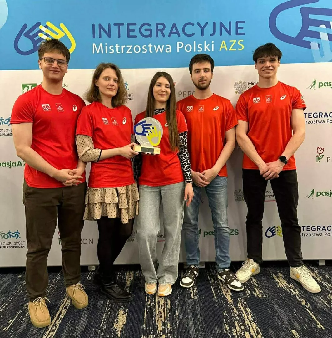 Pięcioro sportowców w czerwonych koszulkach stoi na tle banera z napisem Integracyjne Mistrzostwa Polski AZS