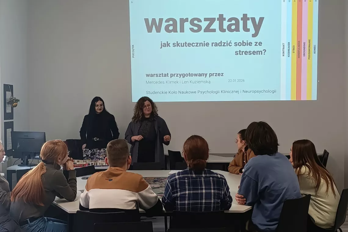 Grupa osób uczestnicząca w warsztatach siedzi w sali seminaryjnej