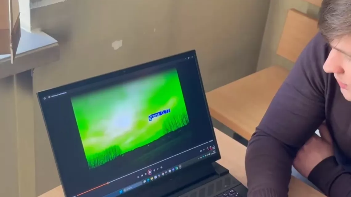 Mężczyzna patrzy w obraz wyświetlający się na ekranie laptopa