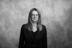 Prof. Anna Masek - czarno-białe zdjęcie, kobieta ma na sobie marynarkę, na którą opadają długie rozpuszczone włosy. Nosi olulary.