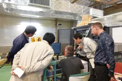 Pięcioro naukowców przygląda się obrazowi na ekranie komputera, pzry którym siedzi jeden z nich. 