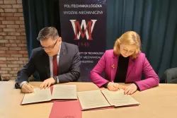 Dwie osoby podpisujące pzry stole dokument umowy. W tle baner z napisem Politechnika Łódzka Wydział Mechaniczny. 