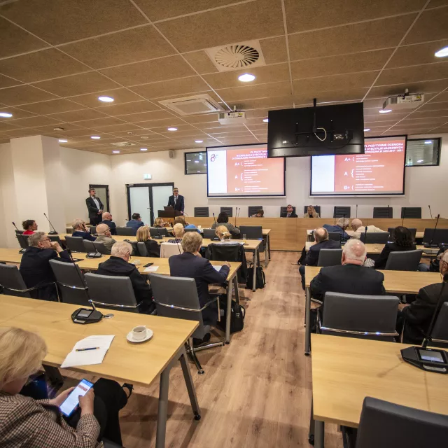 Mężczyzna wygłasza wykład przed zebranymi 