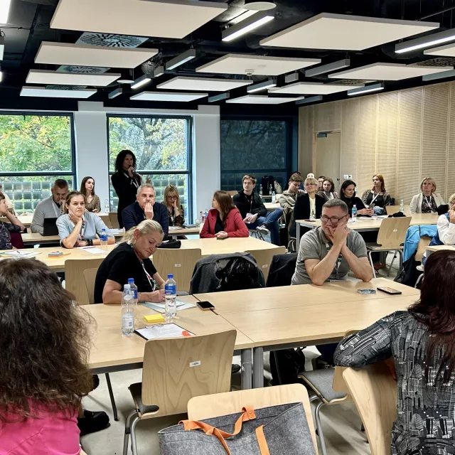 Dyskusje w czasie konferencji, soby siedzą przy stołach w sali seminaryjnej