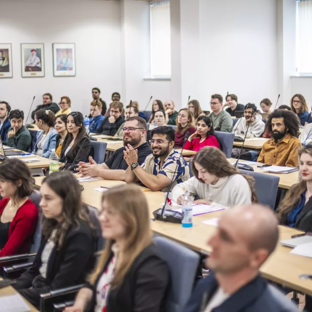 Grupa osób siedzi w sali seminaryjnej